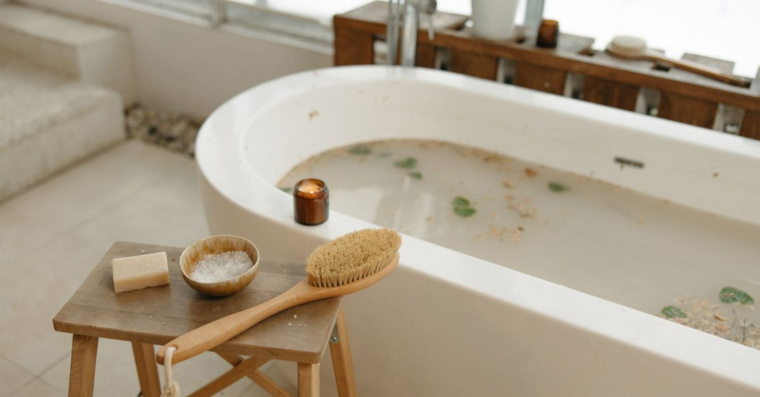 A natural wooden bath and body brush resting on a clean bathroom surface, showcasing its bristles and long handle, representing the best bath & body brushes 2026.