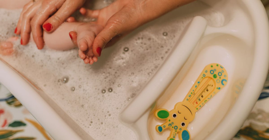 How to choose baby bubble bath & cleansers UK: a selection of gentle, fragrance-free baby bath products displayed on a bathroom shelf.