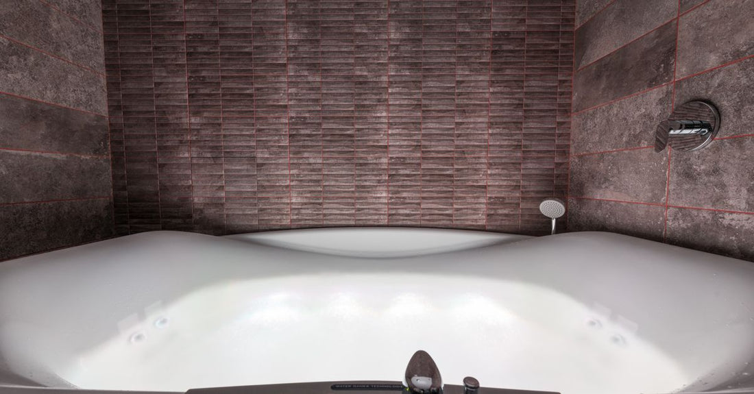 A white vinyl shell-shaped spa bath pillow resting on the edge of a bathtub, showcasing its contoured design for neck support.