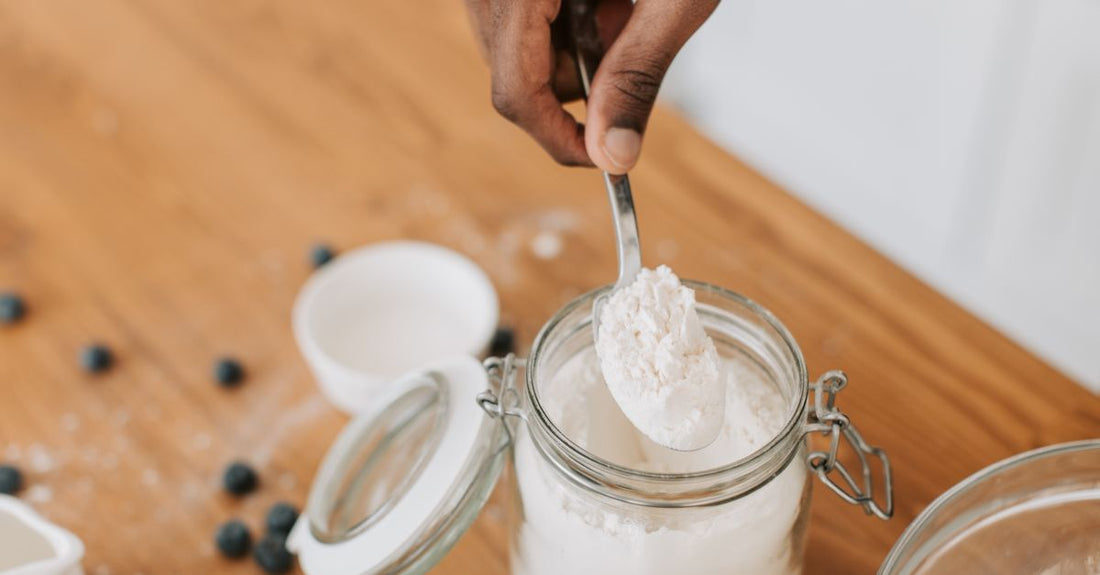 Hair bleach powder in a professional jar next to a mixing bowl, representing a hair bleach buying guide UK.