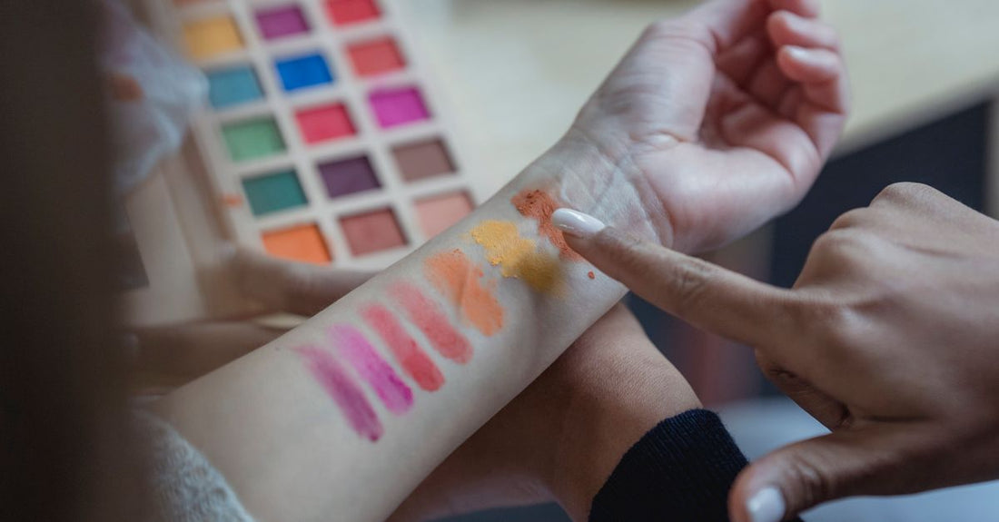 A flatlay of various foundation bottles and swatches on a white surface, illustrating how to choose foundation shade.