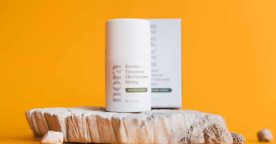 A flatlay of hand cream jars and tubes suitable for eczema, with soothing ingredients like oats and ceramides on a light surface.