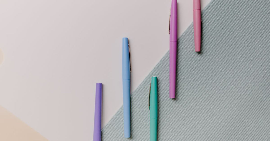 An eyeliner buying guide featuring a matte black liquid eyeliner pen on a white marble surface, demonstrating precision tip.