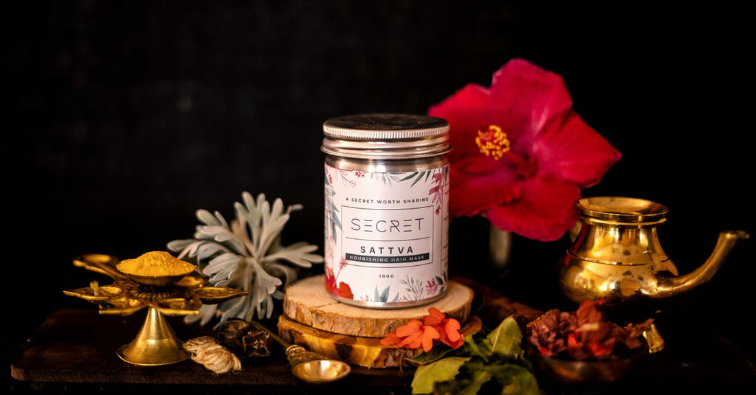 A jar of the best hair mask for damaged hair resting on a marble surface, highlighting its creamy texture.