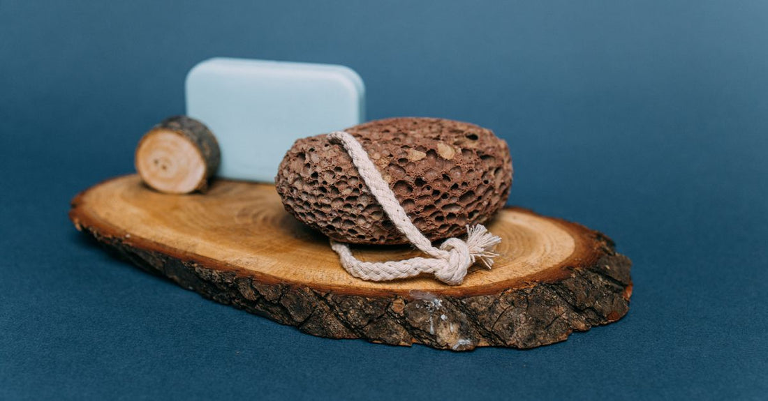 A collection of various bath sponges including natural loofah, konjac, and synthetic poufs arranged on a bathroom shelf, illustrating how to choose bath sponges for different skin types.
