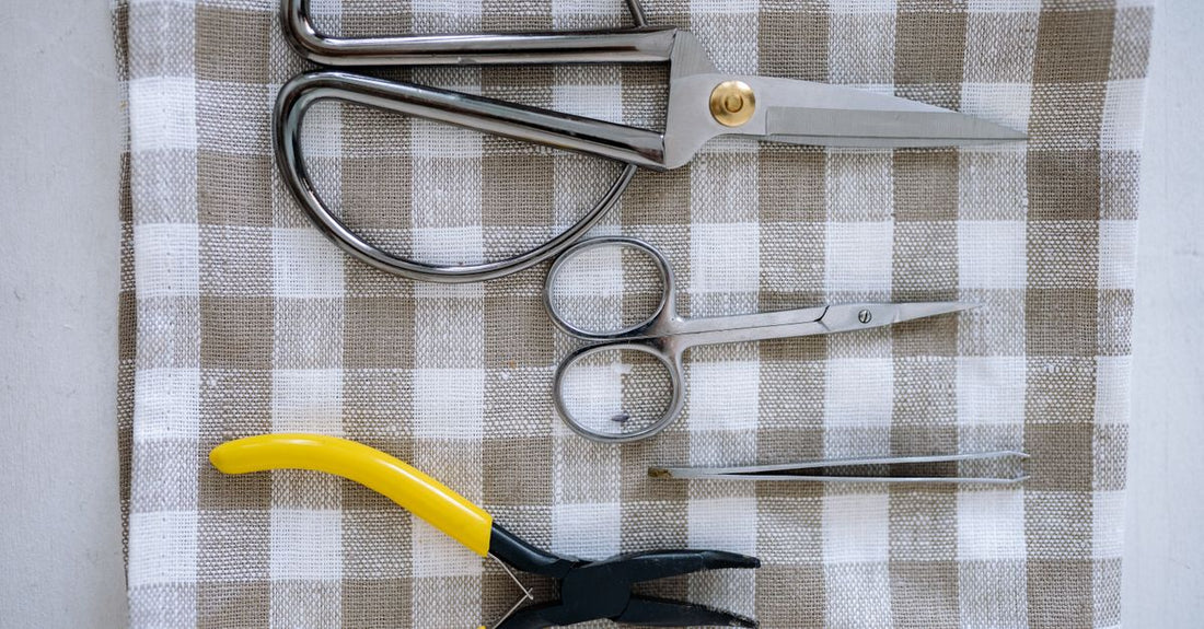 High-quality hair shears resting on a cool marble surface, illustrating a shears buying guide UK for beginners.