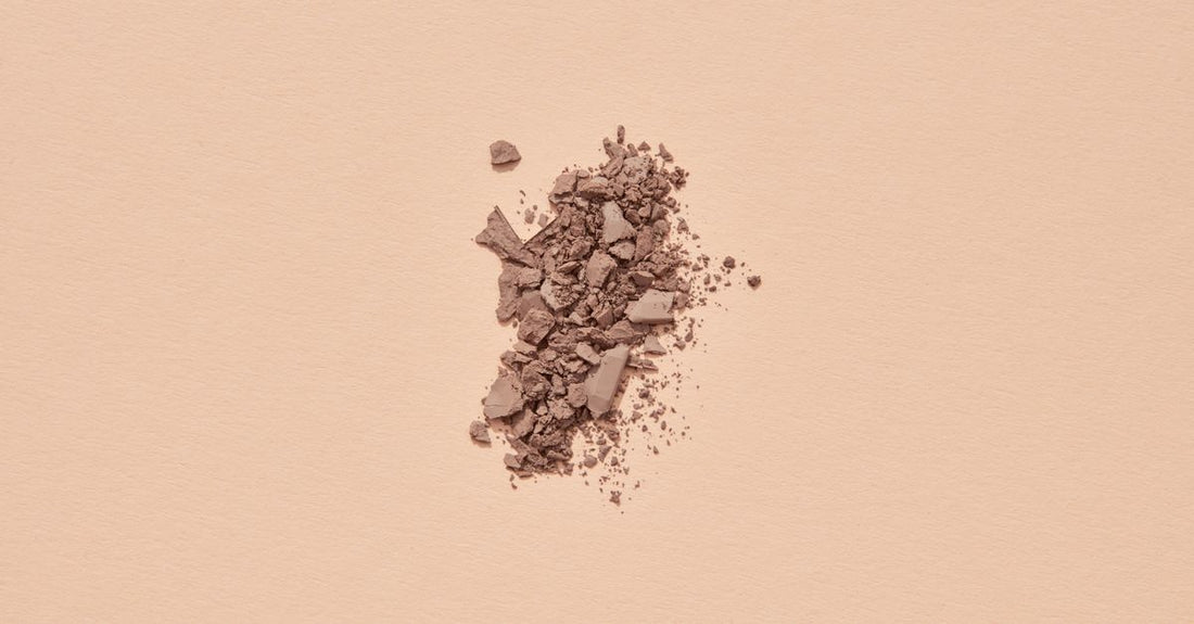 Eyeshadow palette with neutral eyebrow powders and a dual-ended brush on a marble surface, showcasing the best eyebrow color 2026 shade range for UK shoppers.