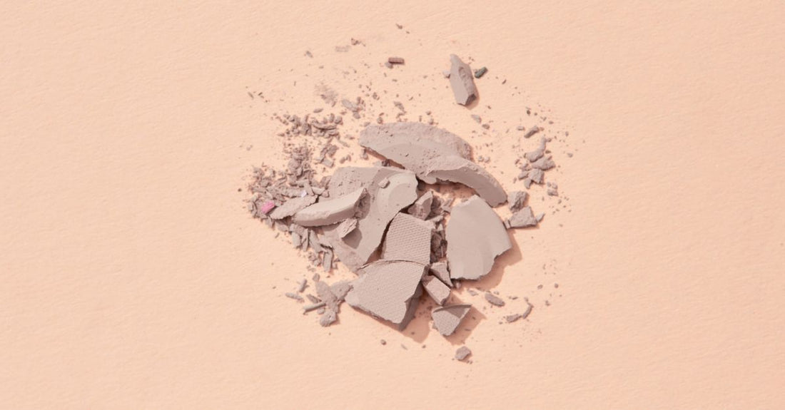 A jar of translucent loose setting powder on a white background, illustrating how to choose powder UK for a flawless makeup finish.