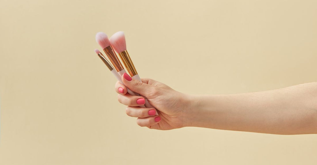 A flatlay of various makeup brushes including foundation, powder, and eyeshadow brushes on a white surface, illustrating an article on how to choose brush sets.