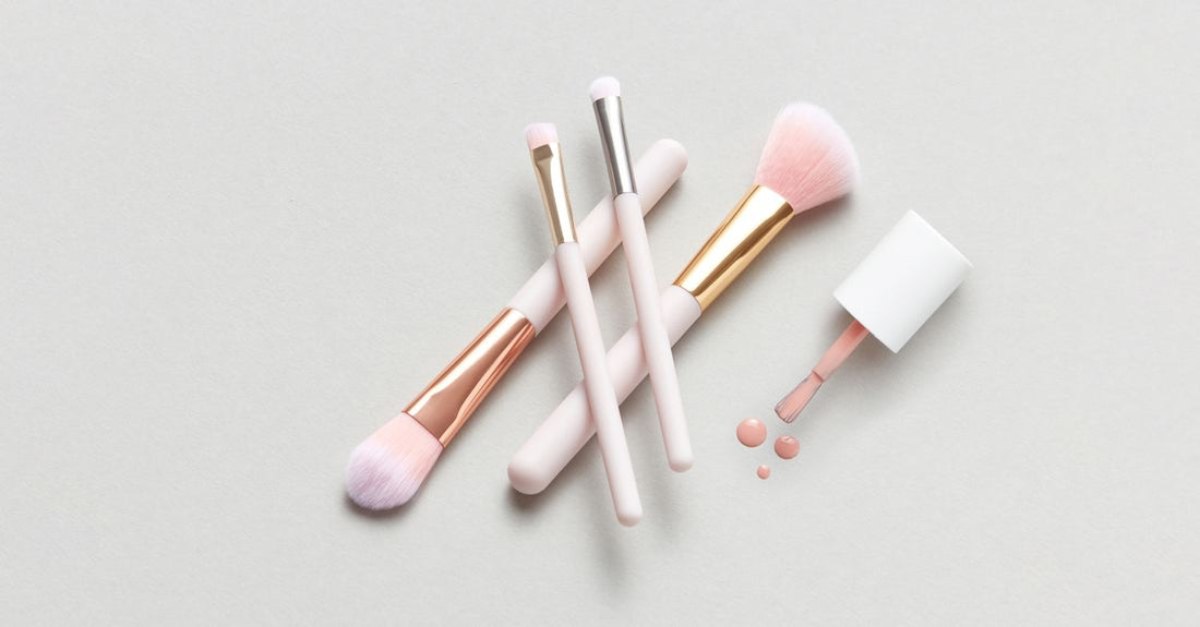 A flatlay of essential acrylic nail tools including a nail drill, brush, and dappen dish on a neutral background, acrylic nail tools buying guide.