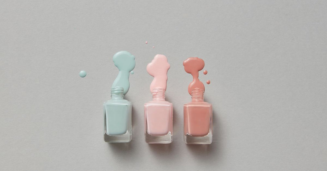 A flatlay of various nail polish bottles in pastel and bold shades, illustrating how to choose nail polish UK based on colour and formula.