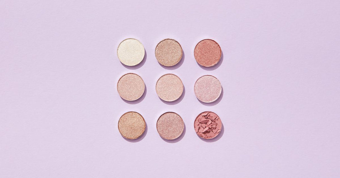 A collection of the best highlighters & luminizers UK 2026, featuring shimmer powders, cream sticks, and liquid illuminators arranged on a clean surface.