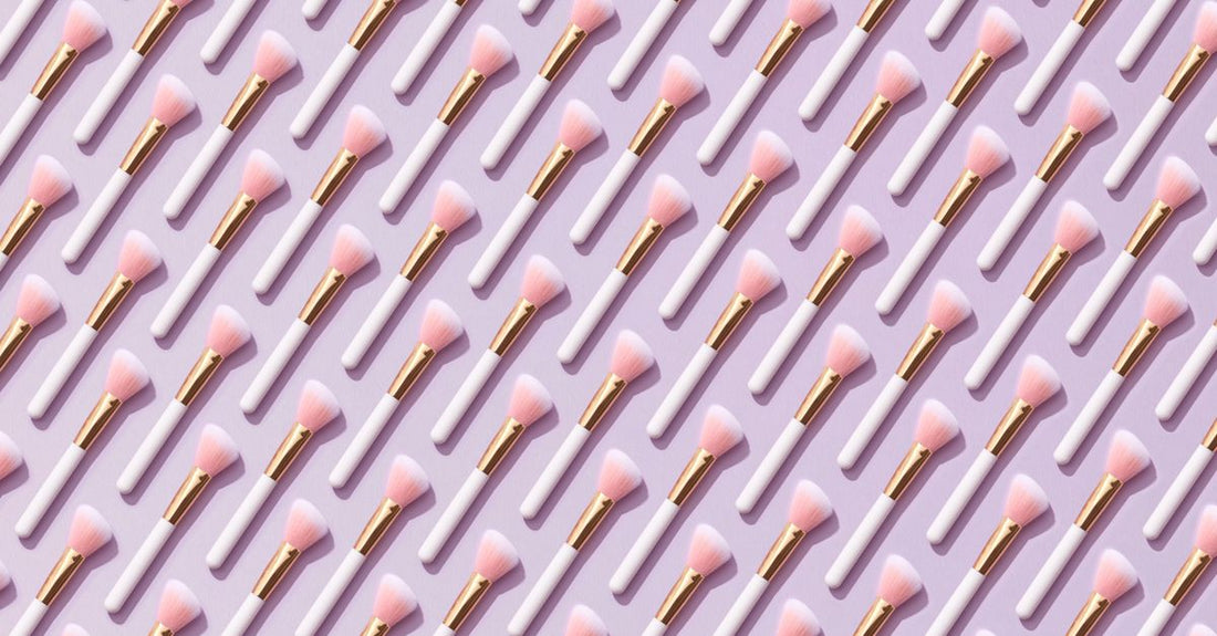 A flatlay of various makeup brush sets with different bristle types and handle designs, illustrating how to choose brush sets for a complete routine.