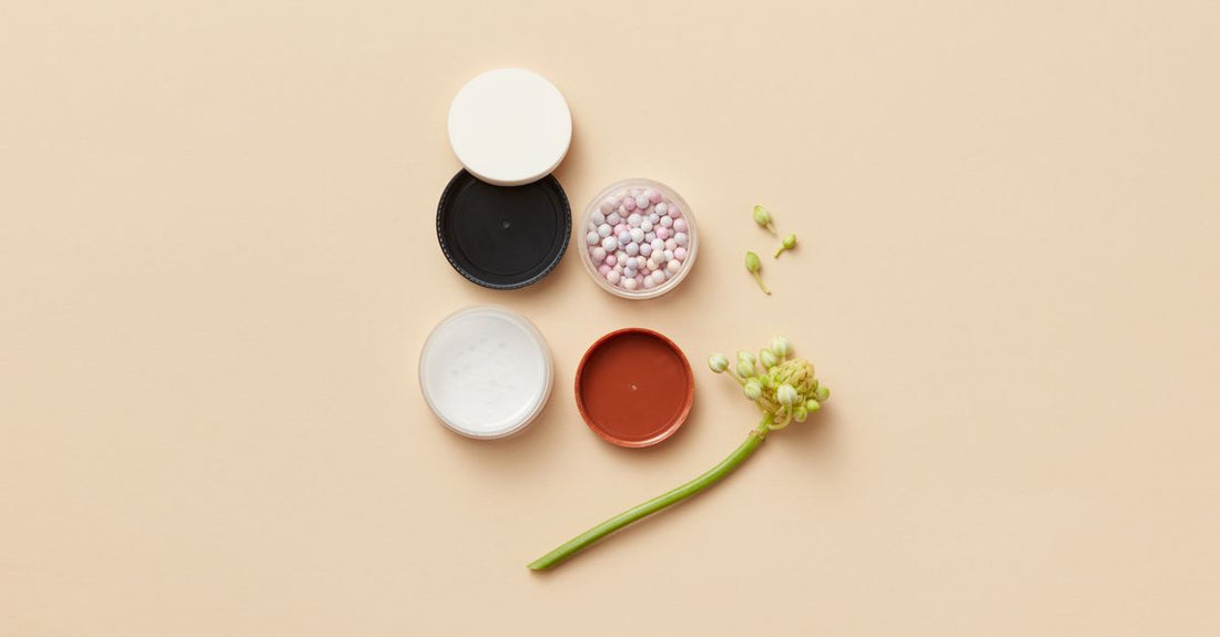 Three clear jars of fine acrylic nail powder in pink, clear and white shades on a white background, demonstrating how to choose acrylic powders by colour and texture.
