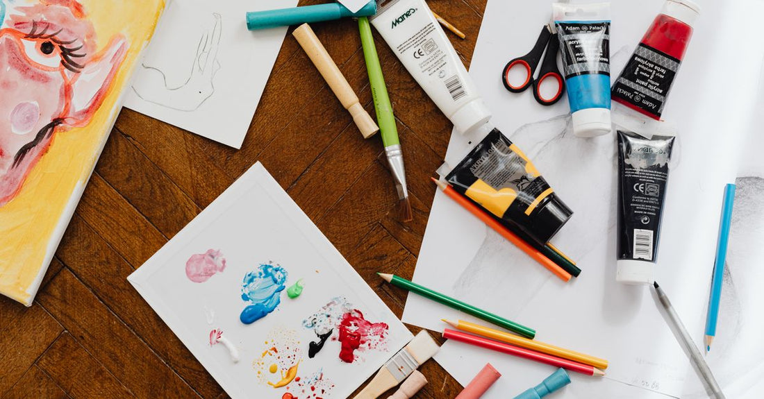 An arrangement of acrylic nail kit components including monomer liquid, acrylic powder and a brush on a white background, illustrating how to choose acrylic nail kits.