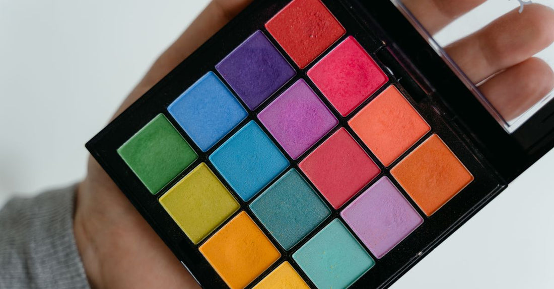 Assorted eyeshadow palettes and single pans on a white surface, illustrating how to choose eyeshadow UK.