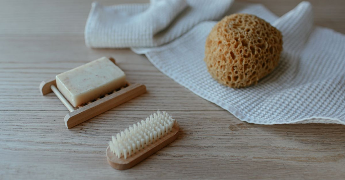 A flatlay of colourful mesh bath sponges and a loofah, representing the best bath sponges 2026 for gentle, hygienic exfoliation.
