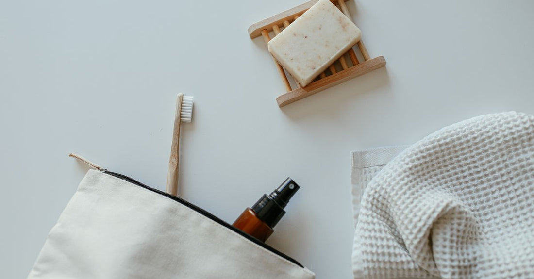 A flatlay of various bath and bathing accessories including bath salts, a loofah, and a candle on a marble surface, illustrating how to choose the right combination.