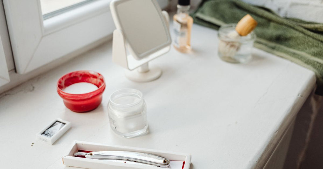 A jar of best hair pomade for men UK on a bathroom shelf with grooming tools