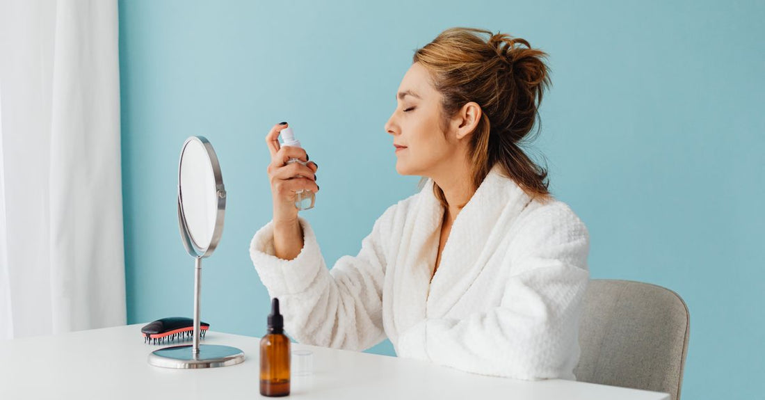 A clear bottle of makeup setting face mist on a clean white background, representing how to set makeup with face mist.