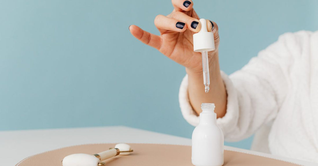 A nail growth serum bottle on a marble surface, illustrating how to use nail growth serum for stronger nails