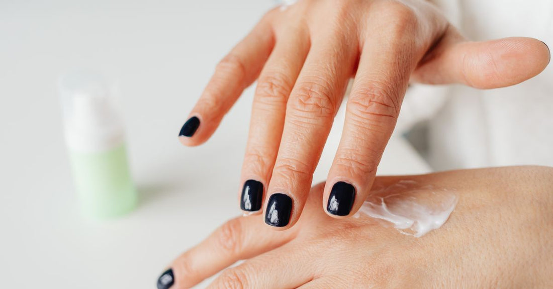 Jar of best cuticle cream for dry cuticles on a white background, with a spatula.