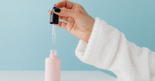 A bottle of best facial self tanner for pale skin UK on a light background, with dropper dispenser.
