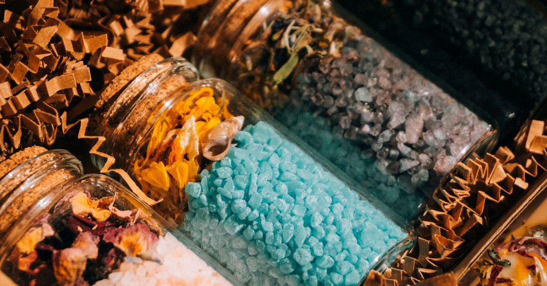 Assorted bath salts in glass jars on a bathroom shelf, showcasing the best bath salts UK 2026 for a relaxing soak
