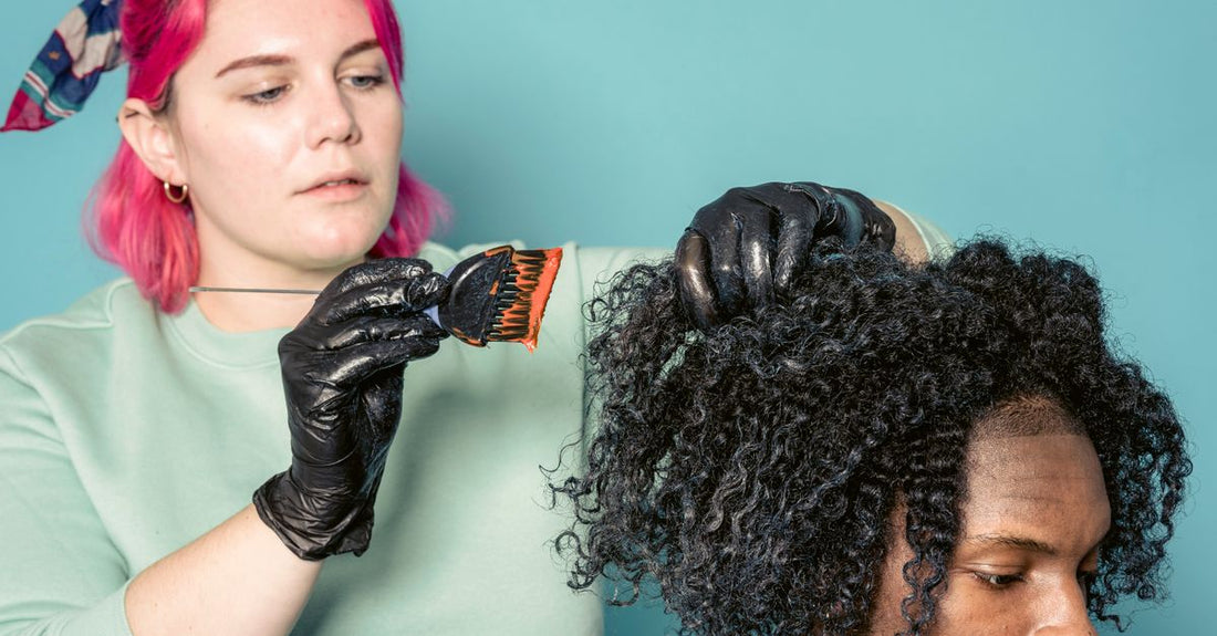 Close-up of a detangling brush gliding through damp curly hair, demonstrating how to detangle curly hair without breakage.