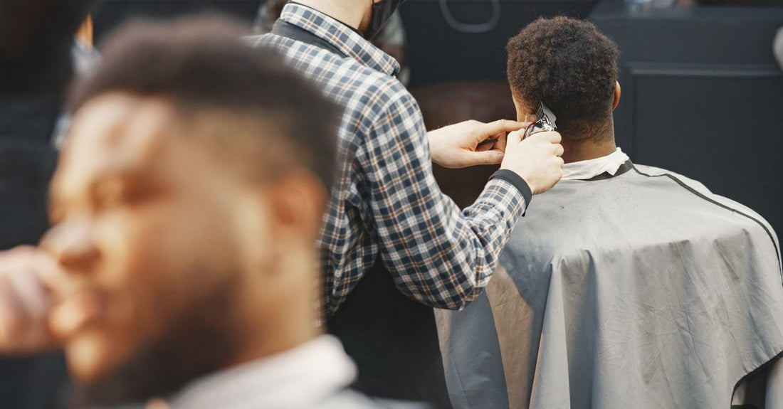 A selection of professional and home hair clippers laid out on a dark grooming station, illustrating how to choose hair clippers.