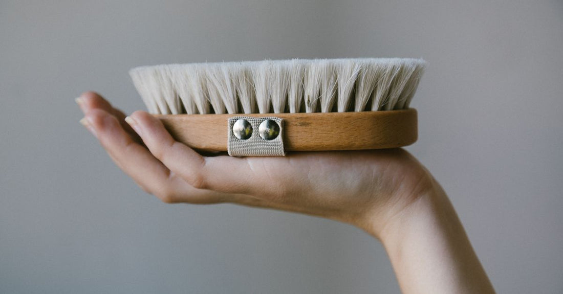 Natural bristle bath and body brush with wooden handle on a clean bathroom surface, illustrating a bath & body brushes buying guide