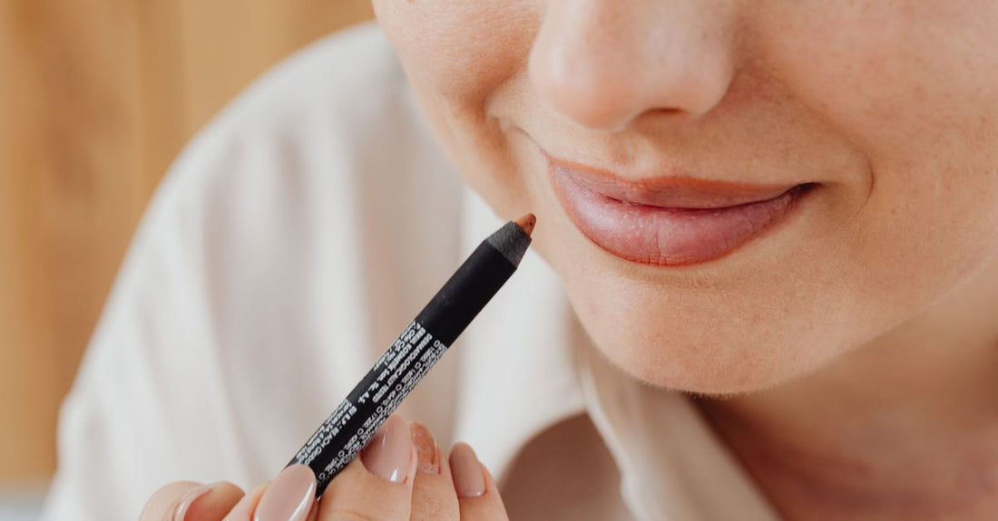 An assortment of lip liner pencils in neutral shades on a flat surface, demonstrating how to overline lips with lip liner for a fuller look.