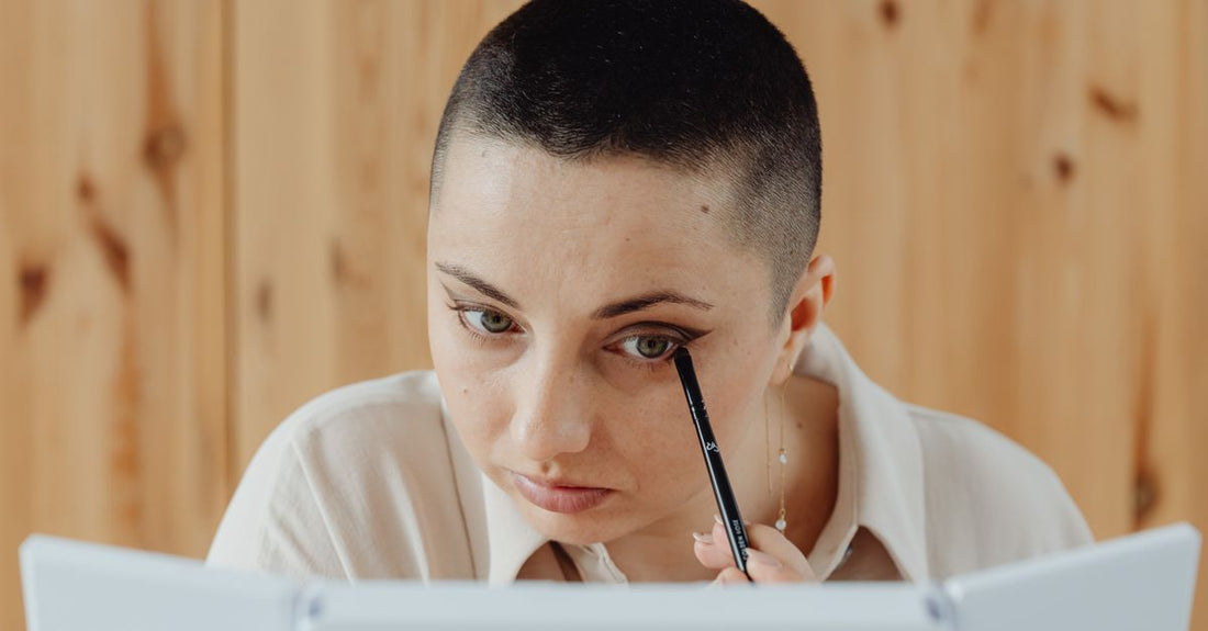 A sleek black eyeliner pen lying on a white marble surface, representing the best eyeliner UK 2026 for precision and style.