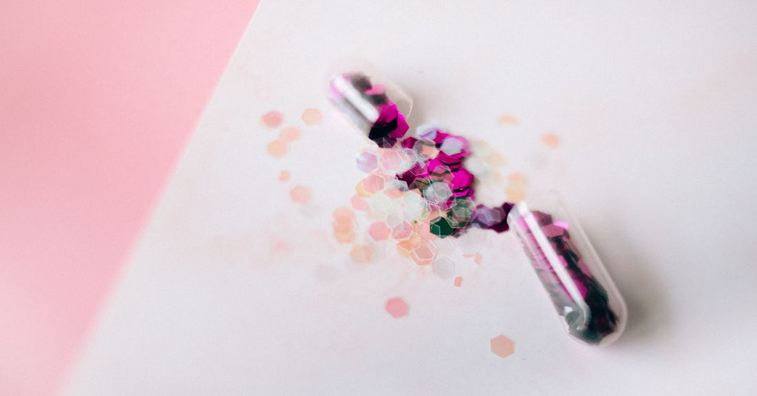 Assorted jars of cosmetic-grade glitter in varying colours and sizes, illustrating how to choose glitters for different beauty and craft projects.