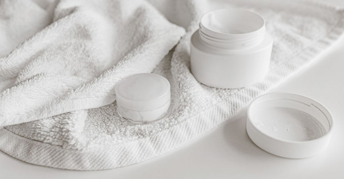 Face moisturizers buying guide UK: flatlay of moisturiser jars and skincare products on a clean surface.