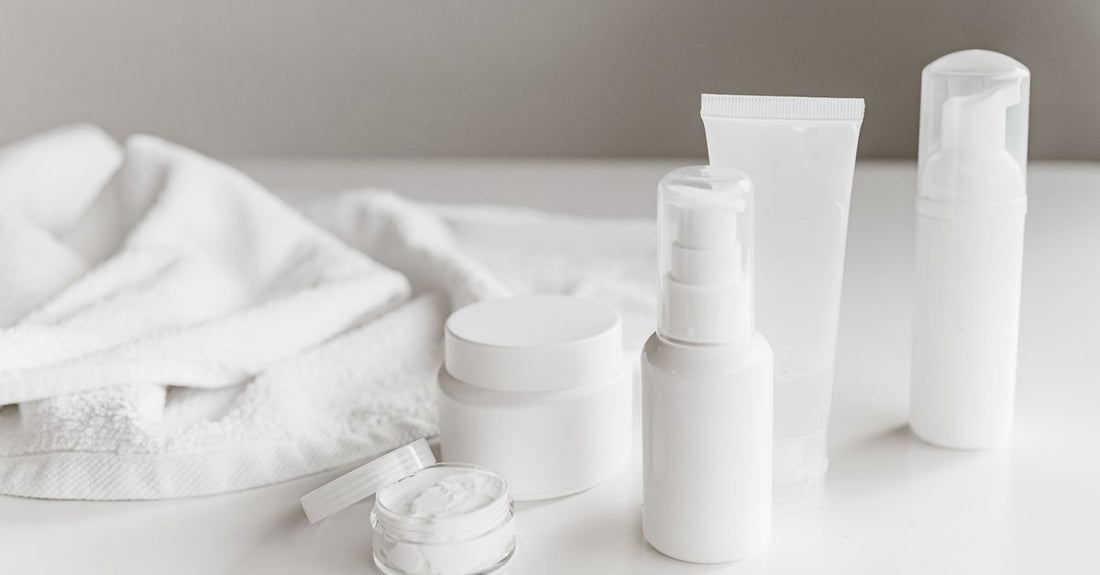 A flatlay of various aftercare skincare products including cleansers, moisturisers, and spot treatments on a clean white background, illustrating an aftercare products buying guide UK.