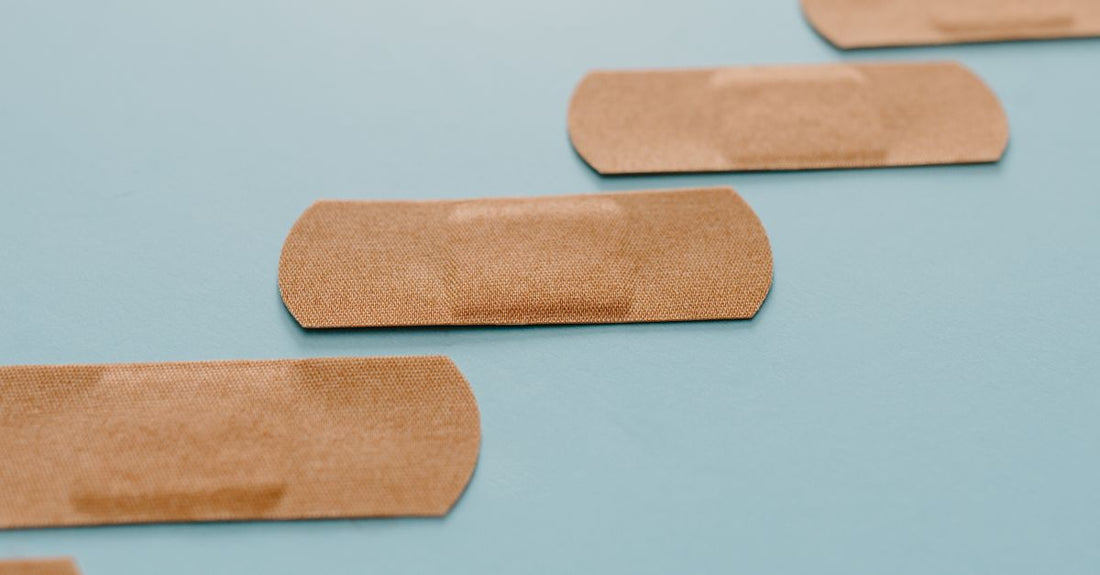 A flatlay of best adhesive bandages 2026 in various shapes and sizes on a clean white surface, including waterproof and hydrocolloid types.