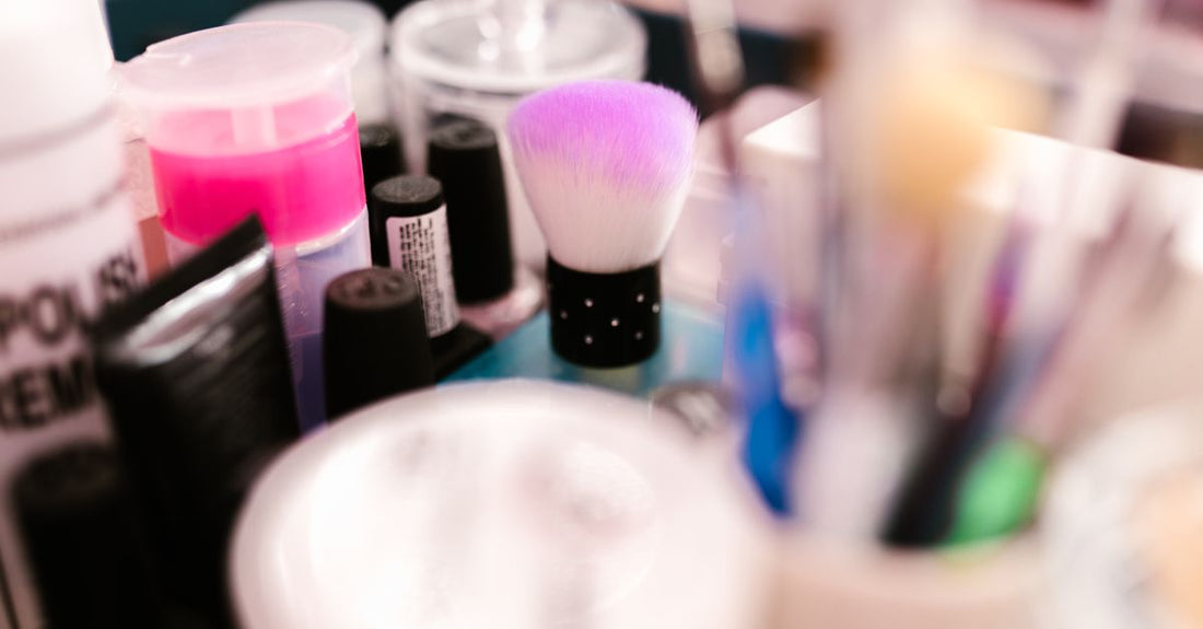 A selection of professional dip powder nail kit with coloured powders, base and activator liquids on a clean beauty desk.
