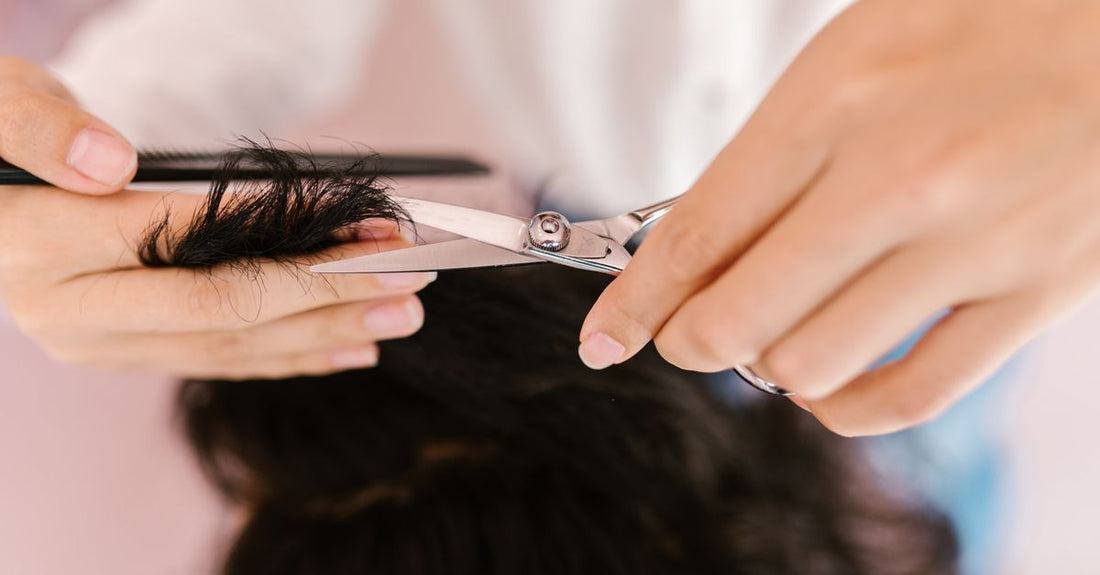 A pair of stainless steel eyebrow scissors with a curved blade resting on a clean white surface, representing a comprehensive eyebrow scissors buying guide for UK shoppers.
