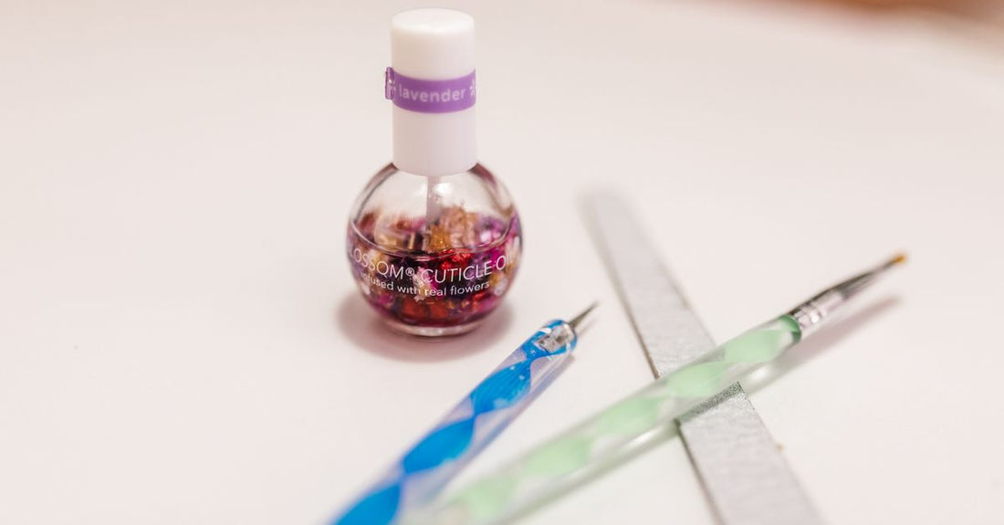 A flatlay of various cuticle pushers including metal, wooden, and ceramic tools on a light background, illustrating how to choose cuticle pushers for safe manicures.