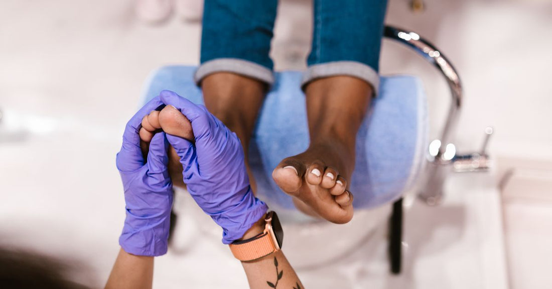 A selection of foot creams and lotions on a bright surface, illustrating how to choose the right formula for dry summer feet.