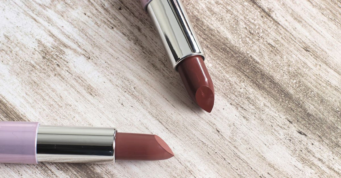 Lipstick buying guide UK showing a selection of lipstick tubes in a flatlay arrangement with colour swatches