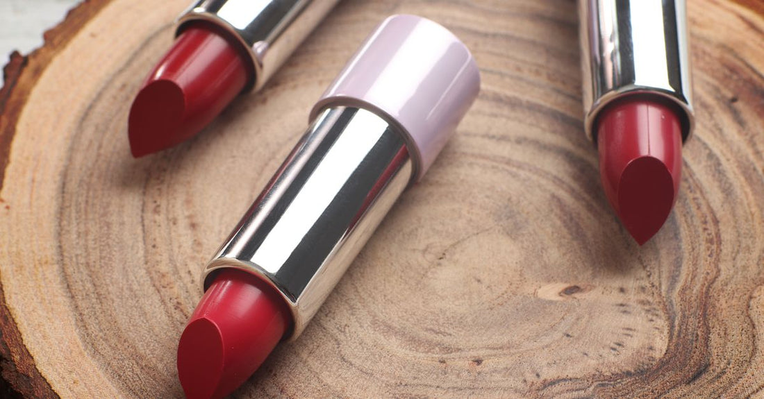A flatlay of various lipsticks, glosses and lip liners arranged on a marble surface, illustrating how to choose lips products.