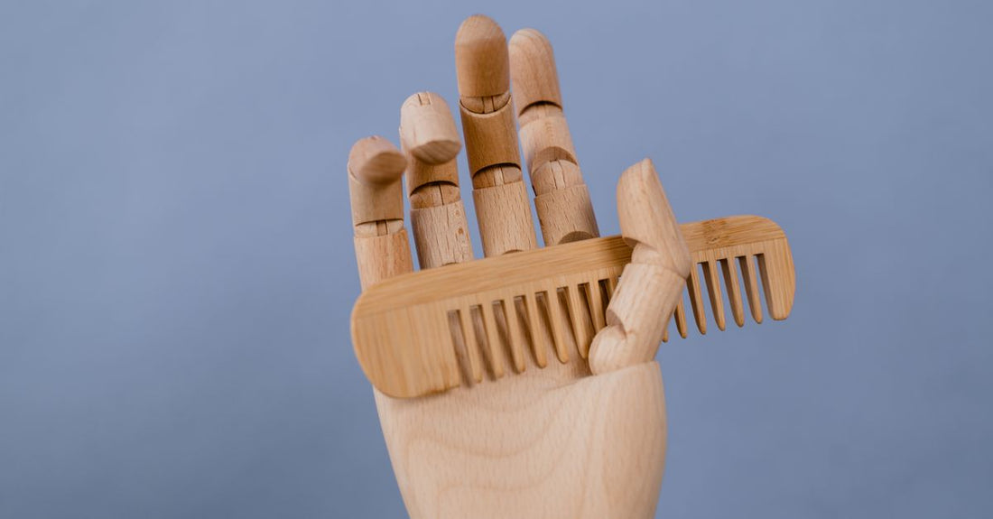 Two wooden beard and mustache combs resting on a dark textured surface, showcasing fine and wide tooth spacing for beard grooming.