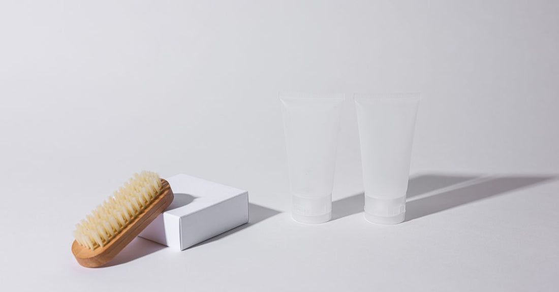 A neatly arranged flatlay of a facial skincare kit with cleanser, toner, serum, and moisturiser on a light background.