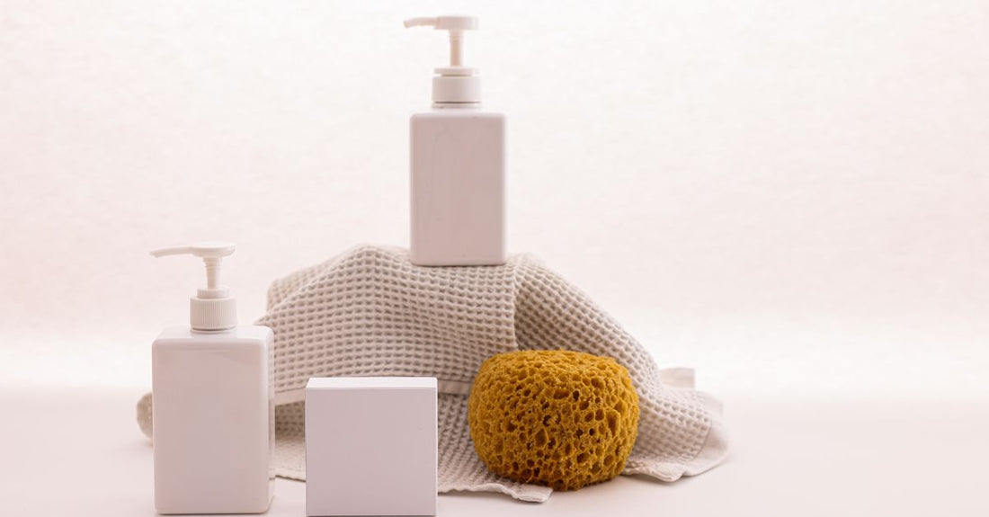 A white bottle of best hand soap for dry hands UK, surrounded by minimalist bathroom accessories on a marble surface.