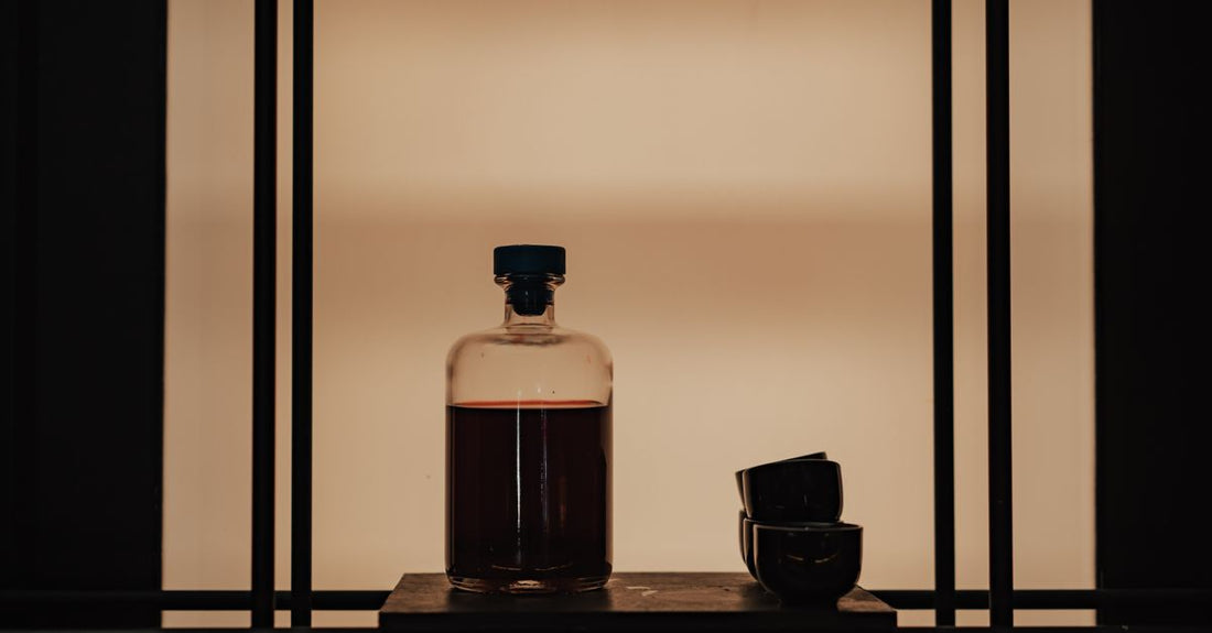 A collection of classic cologne bottles on a glass shelf, illustrating a cologne buying guide for finding a signature scent.