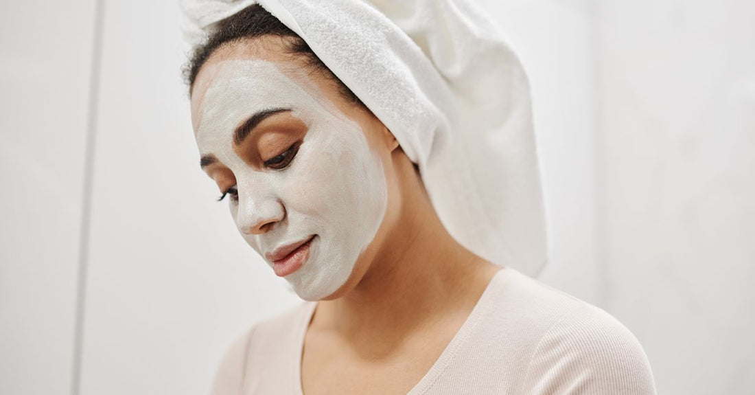 A selection of face masks including a clay mask in a jar, sheet masks, and a sleeping mask on a clean surface, illustrating a masks buying guide.