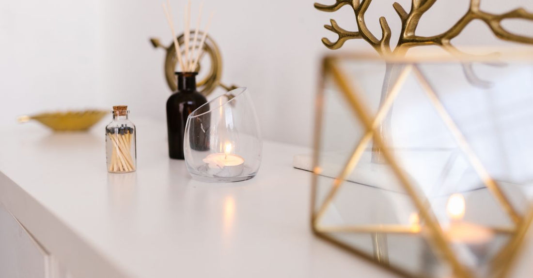 A row of three home fragrance diffusers on a shelf: a reed diffuser, an ultrasonic mist diffuser and a nebulising diffuser, illustrating how to choose diffusers UK.