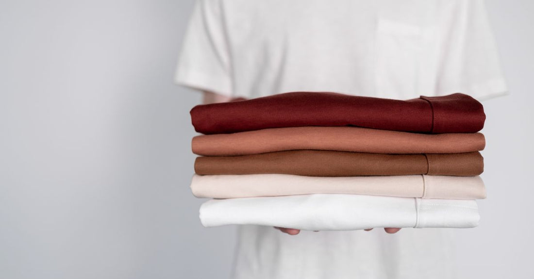 A flatlay of stacked white cotton and muslin face cloths with a cleansing towelette pack, illustrating a cloths & towelettes buying guide.